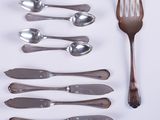 a lot of spoons and forks laid out on the table