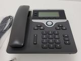 a telephone that is sitting on a table next to a charger