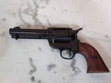 un revolver posé sur un plan de travail en marbre, muni d'une crosse en bois