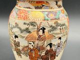a vase with a painting on it sitting on a table