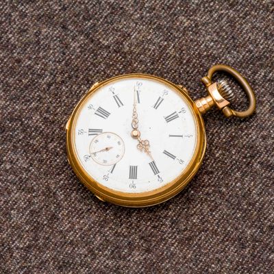 une montre de poche en or avec des chiffres romains
