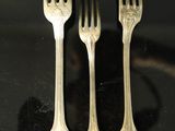 three forks that are sitting on a table
