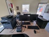 a desk with two computers and a printer on it
