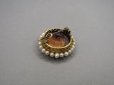 gold and pearl broochle with a picture of a woman ' s face in the center