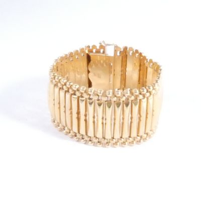 une image d'un gros plan d'un bracelet en or sur un fond blanc