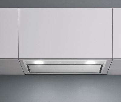 une photo d'une cuisine blanche équipée d'une cuisinière avec four intégré et d'une hotte aspirante