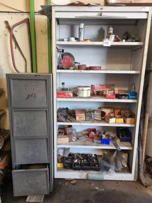 une armoire métallique sur laquelle sont posés de nombreux objets, dans un garage