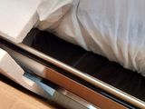 a bed with a white comforter and white sheets in a box