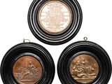 three bronze medallions with a picture of a man and a woman in a boat