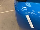 a close up of a blue car with a sticker on it