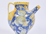 a blue and yellow vase sitting on a white surface