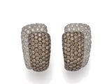 une paire de boucles d'oreilles en diamant marron et blanc sur fond blanc
