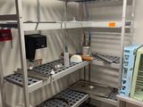 une étagère métallique sur laquelle sont posés un micro-ondes et un four à micro-ondes