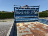 a blue truck with rust on the bed parked in a parking lot
