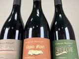 three bottles of wine are lined up on a table
