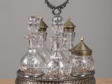 une carafe en argent et en verre posée sur une table en bois