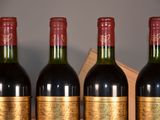 three bottles of red wine are lined up on a shelf
