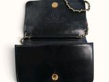 a black purse with a chain hanging from it ' s side