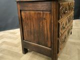 a wooden chest of drawers on a parquet floor