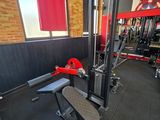 une salle de sport équipée d'un banc, d'haltères et d'autres appareils
