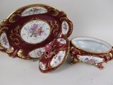 an image of a red and gold plate with a bowl and saucer