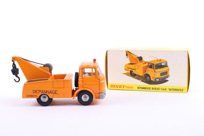 an orange toy truck with a crane in front of a box