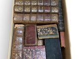 a box full of old books sitting on a white surface