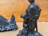 deux figurines représentant une femme et un poisson posées sur une table