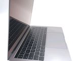 a silver laptop with a black keyboard on a white surface