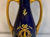 a blue and gold vase sitting on a white surface