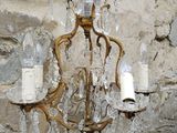 a chandelier hanging from a stone wall in a room