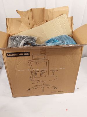une boîte en carton contenant une chaise et d'autres objets, posée sur une surface blanche