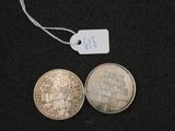 two coins on a black surface with a price tag