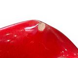 a red bowl that has a hole in it
