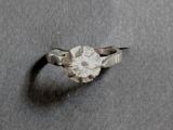une bague sertie d'un diamant, posée sur une table