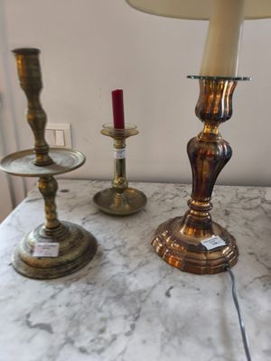 trois bougies posées sur une table où se trouve une lampe
