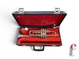 a red case with a trumpet in it on a white surface