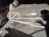 a man standing next to a pile of food wrapped in plastic