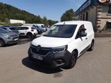 La camionnette blanche est garée devant un grand immeuble.