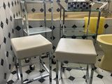 deux tabourets dans une salle de bains équipée d'un lavabo et d'une baignoire