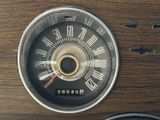 a close up of a speedometer on a wooden table