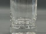 a clear glass vase sitting on a table with a black background