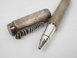 a pen that is laying next to a corkscrew