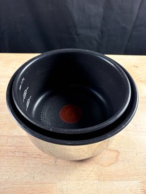 un bol noir posé sur une table en bois, sur fond noir