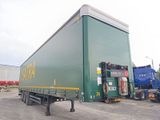 un gros camion vert garé sur un parking