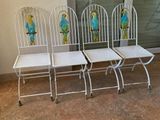 trois chaises en métal blanc placées les unes à côté des autres devant une porte vitrée