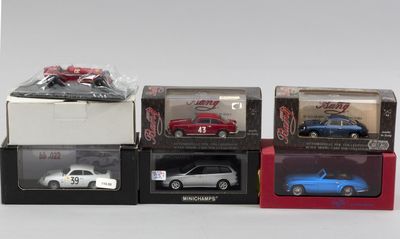 quatre modèles réduits de voitures dans des boîtes posées sur une table