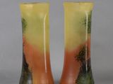 pair of yellow and green vases with trees on them against a gray background