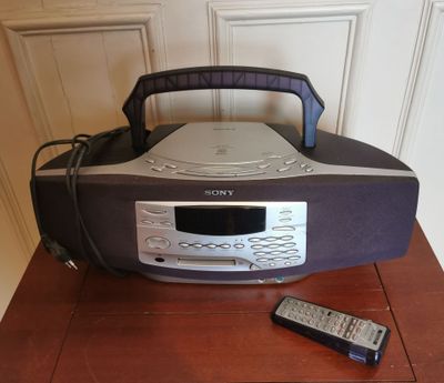 une radio et une télécommande posées sur une table près d'un mur