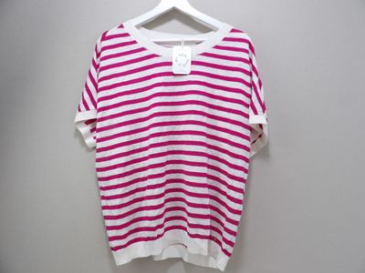 pink and white striped t - shirt on hanger against white wall